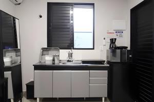 una cucina con lavello e microonde di Studio I - Com Ar Condicionado a Jundiaí