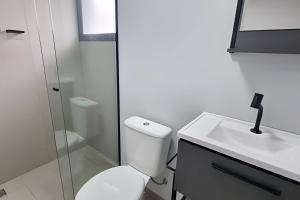 un bagno bianco con un water e un lavandino di Studio I - Com Ar Condicionado a Jundiaí Altre 4 foto