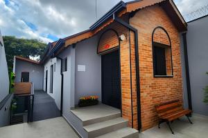 un edificio in mattoni con una porta da garage nera e scale di Studio I - Com Ar Condicionado a Jundiaí