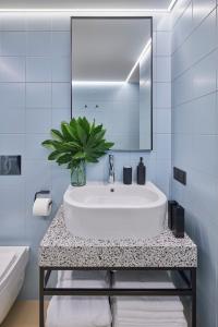 a bathroom with a sink and a mirror at ROOMA Apartments in Vilnius +99 photos