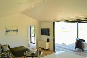 a living room with a couch a table and a tv at Tihi in Otorohanga +21 photos