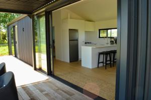 an open kitchen and living room with sliding glass doors at Tihi in Otorohanga
