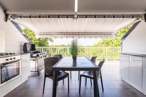 a kitchen and dining room with a table and chairs at appartement haut standing au grands fonds du moule, 6 pers, très spacieux in Le Moule