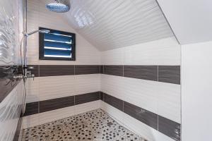 a bathroom with a shower with black and white tiles at appartement haut standing au grands fonds du moule, 6 pers, très spacieux in Le Moule +27 photos
