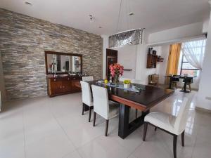 a dining room with a wooden table and white chairs at Enchanted Haven in Puerto Baquerizo Moreno