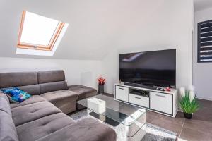 a living room with a couch and a flat screen tv at appartement haut standing au grands fonds du moule, 6 pers, très spacieux in Le Moule