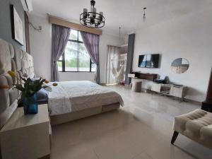 a bedroom with a bed and a tv and a couch at Enchanted Haven in Puerto Baquerizo Moreno