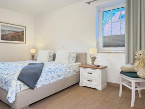 a bedroom with a bed with a teddy bear sitting on a chair at Öresundhus 2 in Prerow