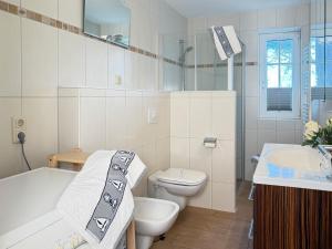 a bathroom with a tub and a toilet and a sink at Öresundhus 2 in Prerow