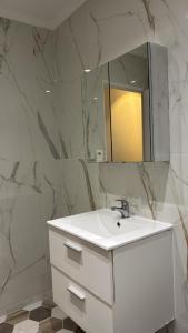 een badkamer met een witte wastafel en een spiegel bij Duplex appartement in Étampes