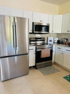 a kitchen with stainless steel appliances and white cabinets at O L S Property in Saint Marks Village
