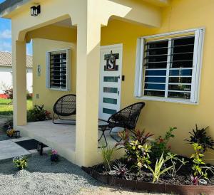a house with two chairs sitting on a porch at O L S Property in Saint Marks Village