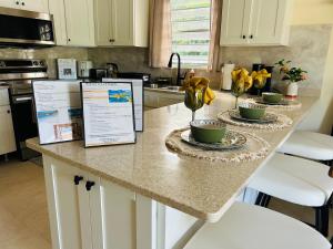 a kitchen counter with two bowls and flowers on it at O L S Property in Saint Marks Village +8 photos