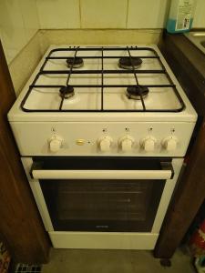 a white stove top oven sitting in a kitchen at Gîte nature sous les châtaigniers in Zonza +7 photos