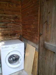 a washer and dryer in a room with a wooden wall at Gîte nature sous les châtaigniers in Zonza