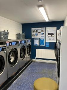 a laundry room with two washing machines and a stool at Sunshine Lodge Haven Lakeland in Flookburgh