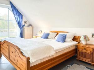 a bedroom with a wooden bed with blue pillows at Windwatt 4 in Zingst
