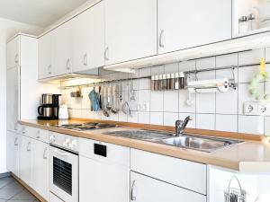 a kitchen with white cabinets and a sink at Windwatt 4 in Zingst