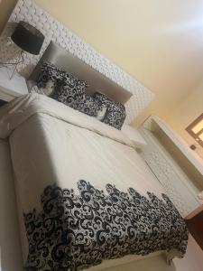 a bedroom with a bed with a black and white comforter at Honey house in Marrakesh