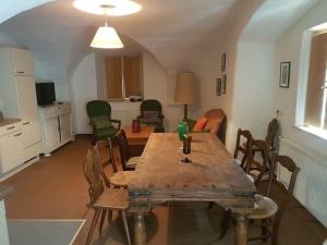 a dining room with a wooden table and chairs at Gut Ottmanach "Josefhof" in Pischeldorf