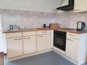 a kitchen with white cabinets and a sink and a stove at Gut Ottmanach "Josefhof" in Pischeldorf