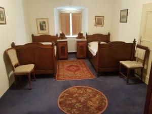 a bedroom with a bed and two chairs and a rug at Gut Ottmanach "Josefhof" in Pischeldorf
