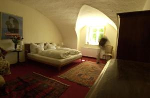 a living room with a bed and a window at Gut Ottmanach "Josefhof" in Pischeldorf +2 photos