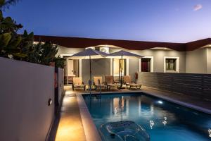 een huis met een zwembad met een parasol bij Olea Apartments in Razáta