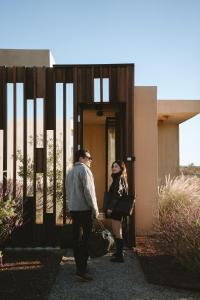 Un uomo e una donna in piedi fuori da un edificio di Equ Hotel Boutique a El Porvenir