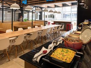 a restaurant with a buffet of food on a table at ibis Ribeirao Preto Shopping in Ribeirão Preto