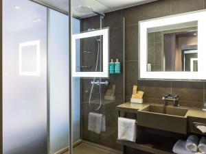 a bathroom with a sink and a shower at Novotel Leeds Centre in Leeds