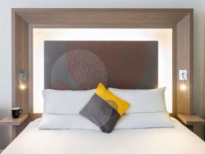 a bed with two pillows on top of it at Novotel Leeds Centre in Leeds