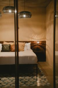 una camera da letto con un letto e due lampade a sospensione di Equ Hotel Boutique a El Porvenir