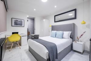 a bedroom with a bed and a yellow chair at Casa Ama in Mexico City