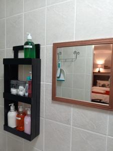 een badkamer met een spiegel en een douche bij Hibiscus B&B in Strand +28 foto's