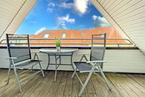 a patio with two chairs and a table on a balcony at Ostseeauszeit in Prerow