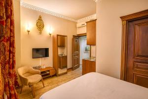 a bedroom with a bed and a chair and a television at BeyPort Hotel Istanbul in Istanbul