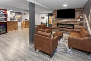 een woonkamer met open haard en tv bij Days Inn by Wyndham Waukegan in Waukegan