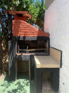 een bakstenen oven met een bankje aan de zijkant van een gebouw bij Los primos in Piriápolis