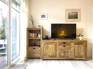 a television on a wooden entertainment center in a living room at Inselperle in Zingst
