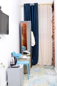 una camera con scrivania blu e specchio di Mpaata Empire Royal Suites a Hoima Altre 20 foto