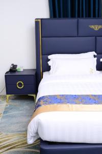 un letto con testiera blu e comodino di Mpaata Empire Royal Suites a Hoima