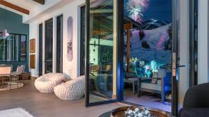a room with glass doors and a table and chairs at Aria Ridge in Steamboat Springs