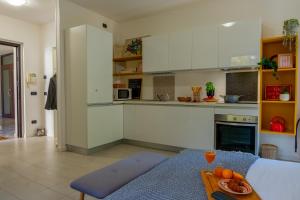 een keuken met witte kasten en een tafel bij AL QUATTRO di Malpensa in Cardano al Campo +8 foto's