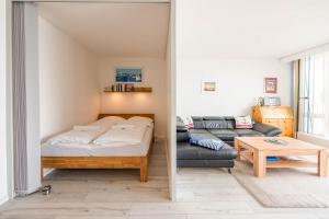 a room with a bed and a couch and a table at Kiel Water 4 in Schilksee