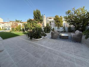 a patio with chairs and tables in a yard at Tavira Casa with Pool in Tavira