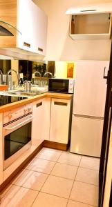 a kitchen with white cabinets and a sink and a refrigerator at Beautiful 36m2 studio apartment & 50m2 terrace in Cannes +7 photos