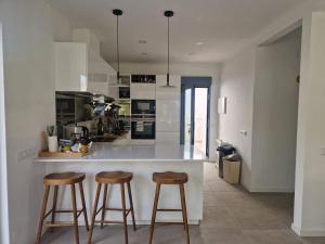 a kitchen with two bar stools and a counter at Tavira Casa with Pool in Tavira