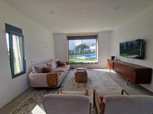 a living room with a couch and a tv at Tavira Casa with Pool in Tavira