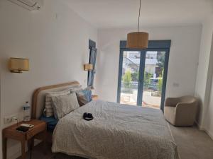 a bedroom with a bed and a chair and a window at Tavira Casa with Pool in Tavira +42 photos